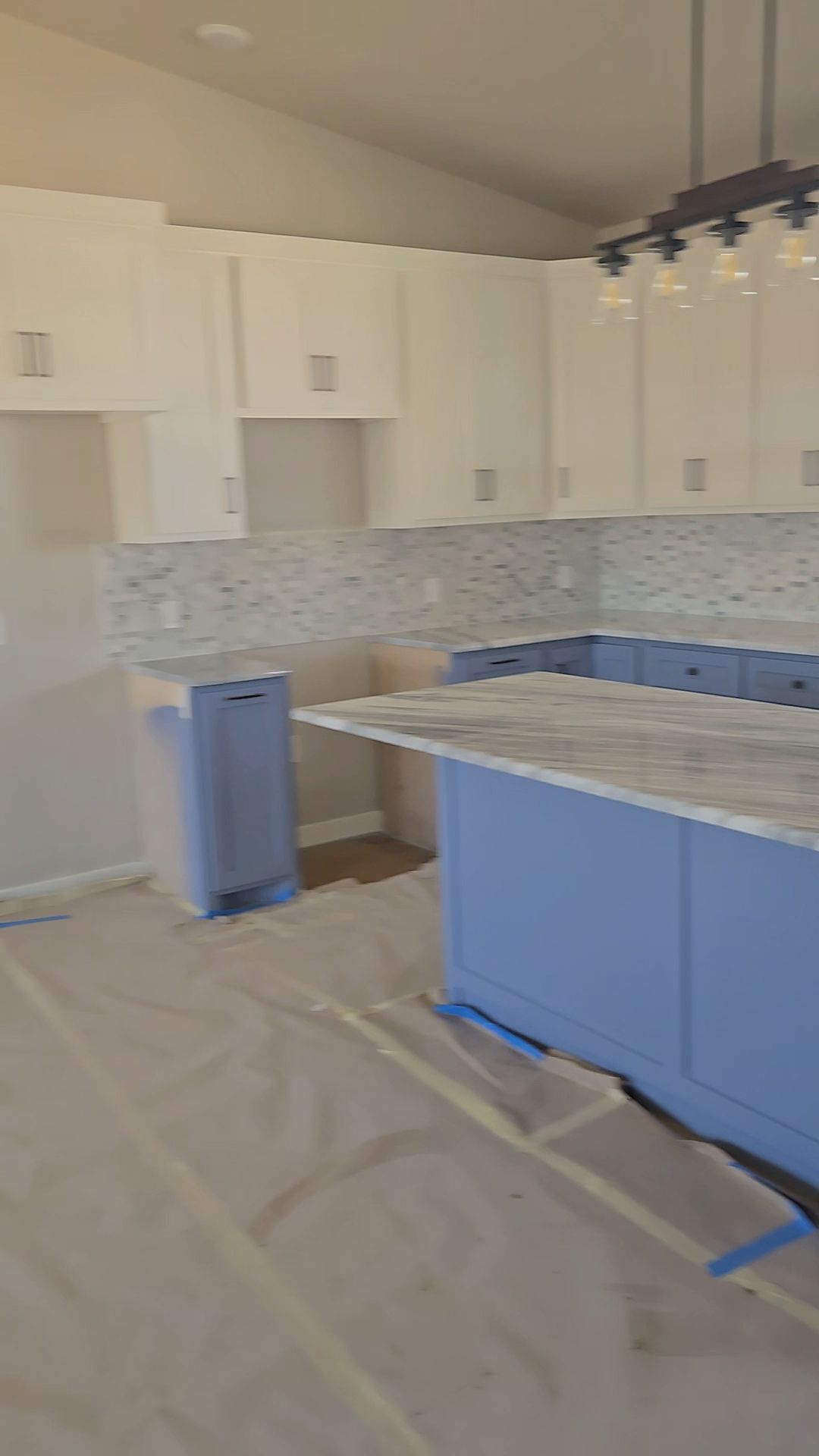 Two-tone kitchen with blue island and white upper cabinets