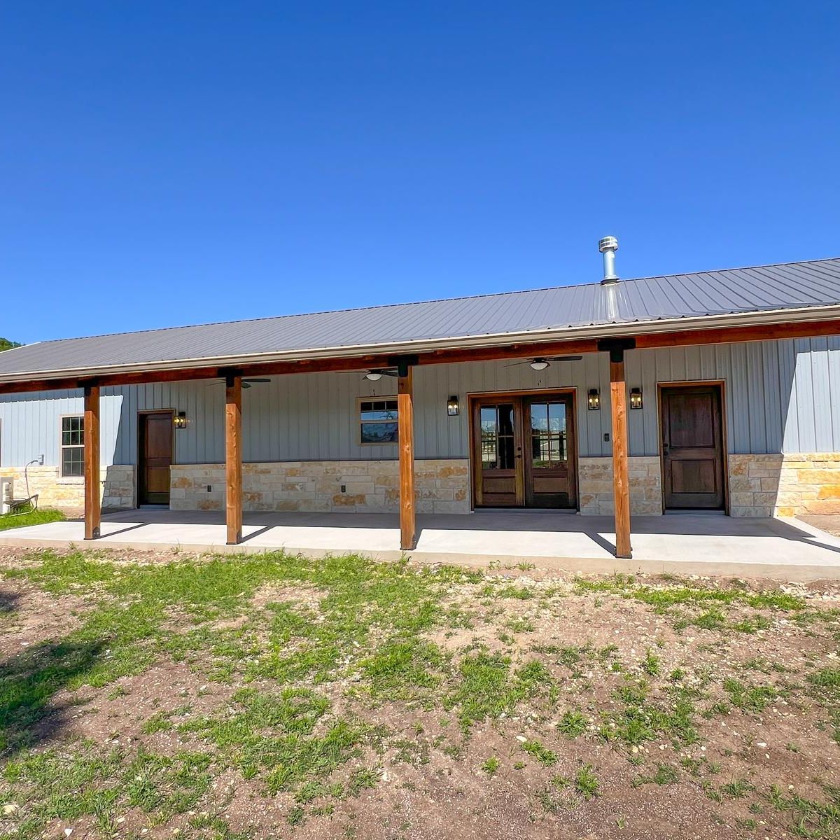Clifton barndominium front porch with stone base and cedar columns