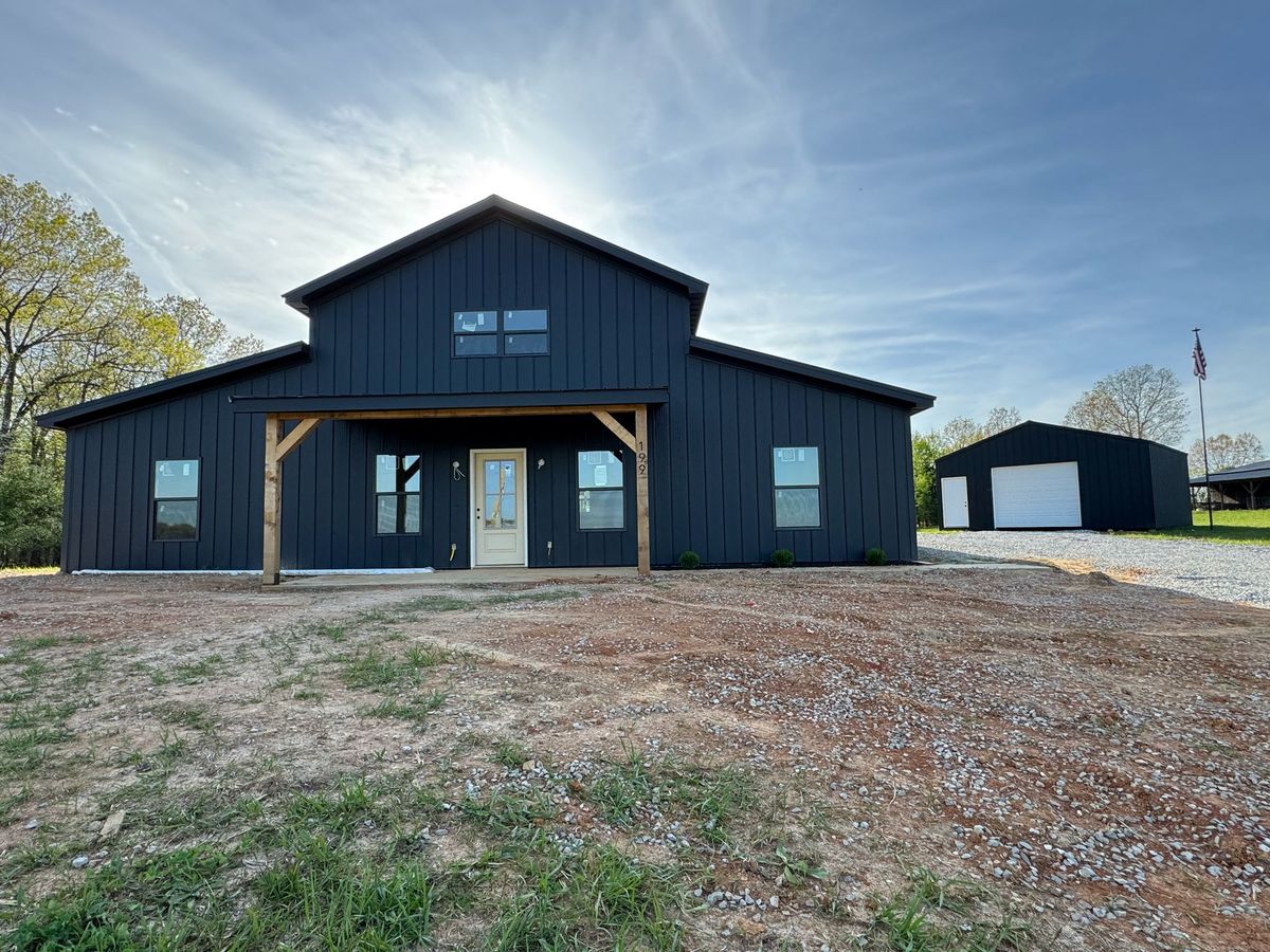 Full front view — two-story charcoal barndominium with detached shop