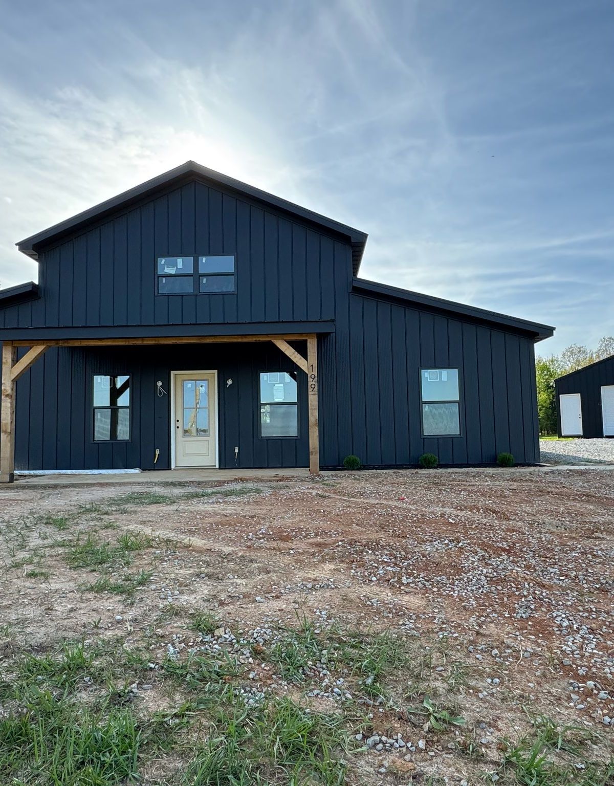 Two-story charcoal barndominium with detached shop in Russellville